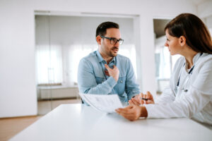 Handsome male patient talking to a female doctor, portrait.